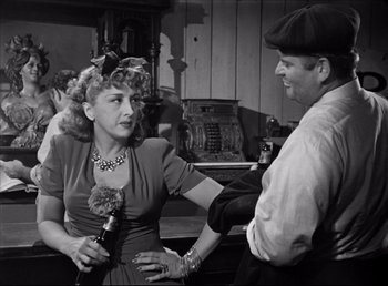 Movie still from “The Southerner” (1945), directed by Jean Renoir – An old photo of a man and a woman talking; Medium shot, Over the shoulder angle