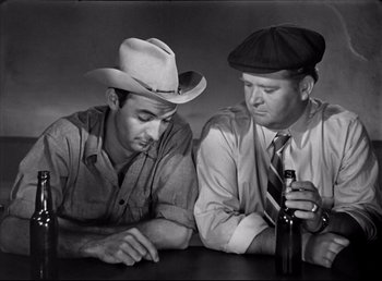 Movie still from “The Southerner” (1945), directed by Jean Renoir – A couple of men sitting next to each other at a table; Medium shot, High angle