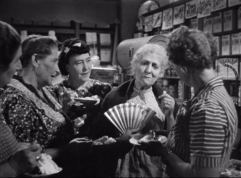 Movie still from “The Southerner” (1945), directed by Jean Renoir – A group of women standing next to each other holding fans; Medium shot, High angle