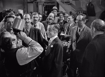 Movie still from “The Southerner” (1945), directed by Jean Renoir – A group of men standing around each other in a room; Medium shot, Over the shoulder angle