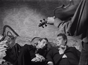 Movie still from “The Southerner” (1945), directed by Jean Renoir – Two men in suits are lying on the floor with a violin; Medium shot, High angle