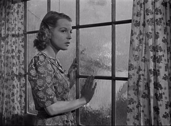Movie still from “The Southerner” (1945), directed by Jean Renoir – A woman standing in front of a window looking outside; Medium shot, Low angle