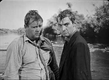 Movie still from “The Southerner” (1945), directed by Jean Renoir – A couple of men standing next to each other near a body of water; Medium shot, Low angle