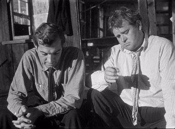 Movie still from “The Southerner” (1945), directed by Jean Renoir – A couple of men sitting next to each other on the ground; Medium shot, Low angle