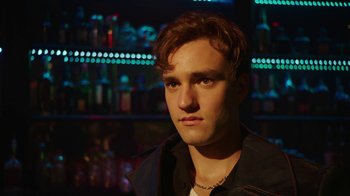 Movie still from “The Space Between” (2021), directed by Rachel Winter – A young man is looking into the distance; Close Up shot, Low angle