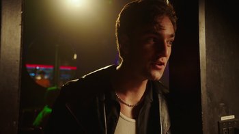 Movie still from “The Space Between” (2021), directed by Rachel Winter – A man in a leather jacket looking to his left; Close Up shot, Over the shoulder angle