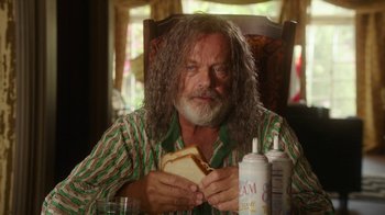 Movie still from “The Space Between” (2021), directed by Rachel Winter – A man sitting at a table eating a sandwich; Close Up shot, Over the shoulder angle