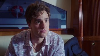 Movie still from “The Space Between” (2021), directed by Rachel Winter – A man sitting on a couch in a living room; Close Up shot, Over the shoulder angle