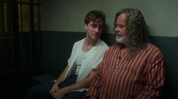 Movie still from “The Space Between” (2021), directed by Rachel Winter – A man and a young man sitting next to each other; Medium shot, Over the shoulder angle