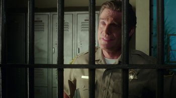 Movie still from “The Space Between” (2021), directed by Rachel Winter – A man standing behind bars in a jail cell; Close Up shot, Over the shoulder angle