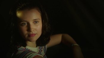 Movie still from “The Space Between” (2021), directed by Rachel Winter – A young woman is posing for a picture; Close Up shot, High angle