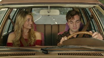 Movie still from “The Space Between” (2021), directed by Rachel Winter – A man and a woman sitting in the back of a car; Medium shot, Over the shoulder angle