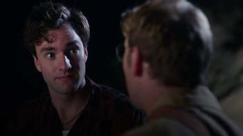Movie still from “The Space Between” (2021), directed by Rachel Winter – A man looking at another man in the dark; Close Up shot, Over the shoulder angle
