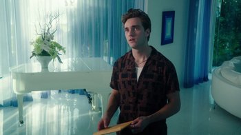 Movie still from “The Space Between” (2021), directed by Rachel Winter – A young man holding a frisbee in a room; Medium shot, Over the shoulder angle