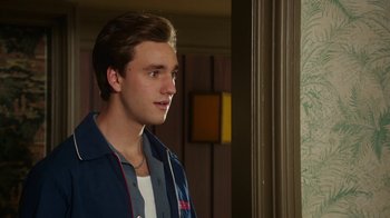 Movie still from “The Space Between” (2021), directed by Rachel Winter – A young man standing in front of a window; Close Up shot, Over the shoulder angle
