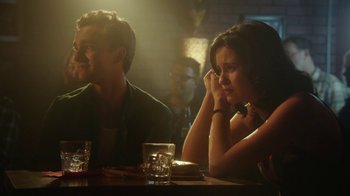 Movie still from “The Space Between” (2021), directed by Rachel Winter – A man and a woman sitting at a table; Medium shot, Over the shoulder angle