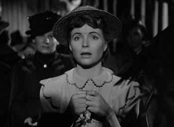 Movie still from “The Spiral Staircase” (1946), directed by Robert Siodmak – A woman with a hat on her head looking at the camera; Close Up shot, Over the shoulder angle