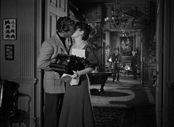 Movie still from “The Spiral Staircase” (1946), directed by Robert Siodmak – A man and a woman kissing in front of a door way; Wide shot, Over the shoulder angle