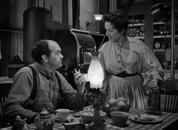 Movie still from “The Spiral Staircase” (1946), directed by Robert Siodmak – An old photo of a man and a woman sitting at a dinner table; Medium shot, High angle