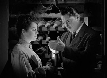 Movie still from “The Spiral Staircase” (1946), directed by Robert Siodmak – An old photo of a man and a young woman; Medium shot, Low angle