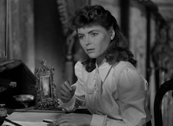 Movie still from “The Spiral Staircase” (1946), directed by Robert Siodmak – A black - and - white photo of a woman sitting at a table; Close Up shot, High angle
