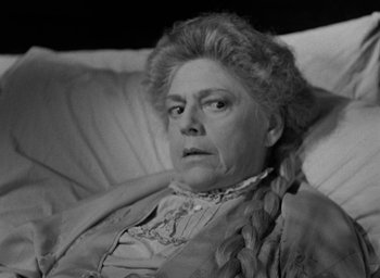 Movie still from “The Spiral Staircase” (1946), directed by Robert Siodmak – An older woman sitting on a couch looking at the camera; Close Up shot, High angle