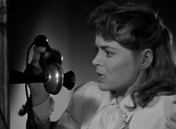 Movie still from “The Spiral Staircase” (1946), directed by Robert Siodmak – A black and white photo of a woman holding a hair dryer; Close Up shot, High angle