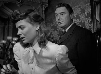 Movie still from “The Spiral Staircase” (1946), directed by Robert Siodmak – A man and a woman standing next to each other in a room; Medium shot, Low angle