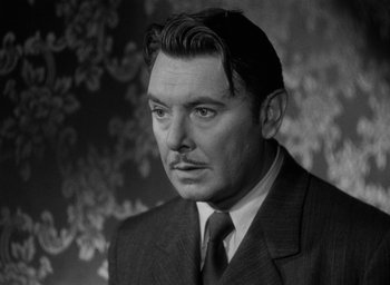 Movie still from “The Spiral Staircase” (1946), directed by Robert Siodmak – An old photo of a man in a suit; Close Up shot, Low angle