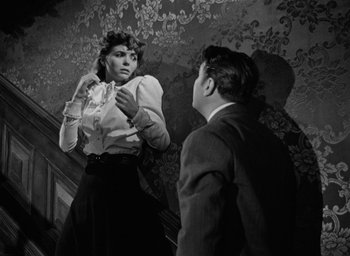 Movie still from “The Spiral Staircase” (1946), directed by Robert Siodmak – A man and a woman are standing in front of each other; Medium shot, Low angle