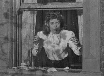 Movie still from “The Spiral Staircase” (1946), directed by Robert Siodmak – An old photo of a woman looking out of a window; Medium shot, Low angle