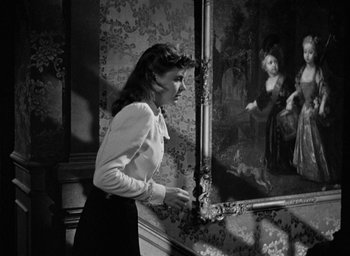 Movie still from “The Spiral Staircase” (1946), directed by Robert Siodmak – A woman standing in front of a painting; Medium shot, High angle