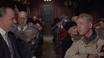 Movie still from “The Spirit of St. Louis” (1957), directed by Billy Wilder – A group of people sitting on a train; Medium shot, Over the shoulder angle
