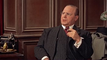 Movie still from “The Spirit of St. Louis” (1957), directed by Billy Wilder – An older man wearing a suit and tie; Close Up shot, Over the shoulder angle