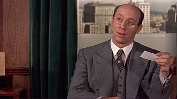 Movie still from “The Spirit of St. Louis” (1957), directed by Billy Wilder – A man in a suit and tie sitting in front of a window; Close Up shot, Over the shoulder angle