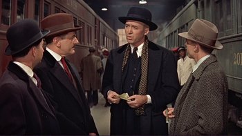 Movie still from “The Spirit of St. Louis” (1957), directed by Billy Wilder – A man wearing a hat and a suit and tie; Medium shot, Over the shoulder angle