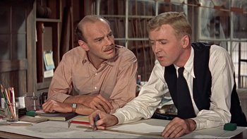 Movie still from “The Spirit of St. Louis” (1957), directed by Billy Wilder – Two men sitting at a table looking at a piece of paper; Medium shot, Over the shoulder angle