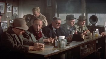 Movie still from “The Spirit of St. Louis” (1957), directed by Billy Wilder – A group of men sitting at a table in a room; Medium shot, Low angle