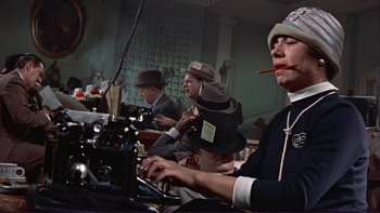 Movie still from “The Spirit of St. Louis” (1957), directed by Billy Wilder – A group of people sitting around a sewing machine; Medium shot, Low angle