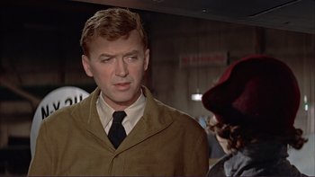 Movie still from “The Spirit of St. Louis” (1957), directed by Billy Wilder – A man wearing a suit and tie standing next to a woman; Close Up shot, Over the shoulder angle