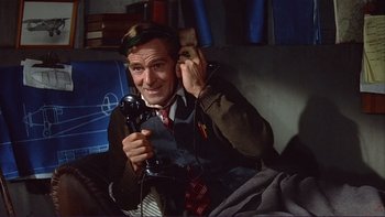 Movie still from “The Spirit of St. Louis” (1957), directed by Billy Wilder – A man sitting in a chair holding a phone; Medium shot, High angle
