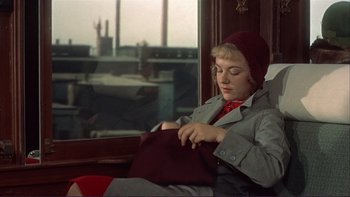 Movie still from “The Spirit of St. Louis” (1957), directed by Billy Wilder – A woman sitting on a train looking at her purse; Medium shot, High angle