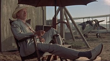 Movie still from “The Spirit of St. Louis” (1957), directed by Billy Wilder – An old man sitting in a chair under an open umbrella; Wide shot, Low angle