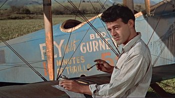 Movie still from “The Spirit of St. Louis” (1957), directed by Billy Wilder – A man holding a brush in front of an airplane; Medium shot, Low angle