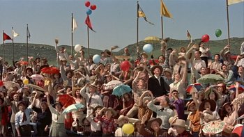 Movie still from “The Spirit of St. Louis” (1957), directed by Billy Wilder – A group of people standing in a crowd holding umbrellas; Wide shot, High angle