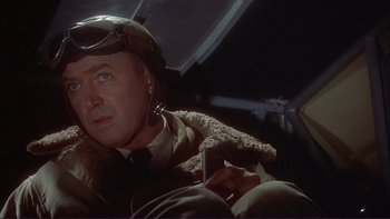 Movie still from “The Spirit of St. Louis” (1957), directed by Billy Wilder – A man in a helmet sitting in an airplane; Close Up shot, Low angle