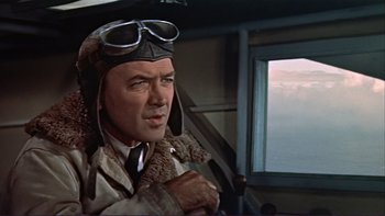 Movie still from “The Spirit of St. Louis” (1957), directed by Billy Wilder – An older man wearing a pilot's jacket and goggles in front of an airplane window; Medium shot, Low angle