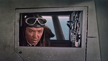 Movie still from “The Spirit of St. Louis” (1957), directed by Billy Wilder – A man in a pilot's uniform looking out of a window; Medium shot, Low angle