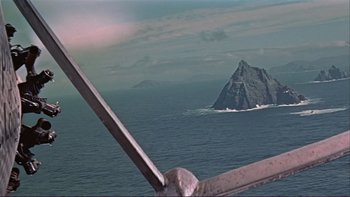 Movie still from “The Spirit of St. Louis” (1957), directed by Billy Wilder – A view from a plane of the ocean with a mountain in the background; Extreme Wide shot, High angle