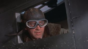 Movie still from “The Spirit of St. Louis” (1957), directed by Billy Wilder – A man wearing goggles looking out of an airplane window; Close Up shot, Low angle
